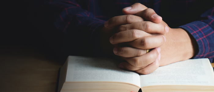 Hands resting on Bible